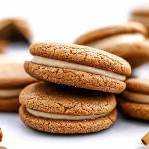 Group of cookies on white surface, emphasizing contrast between crunchy exterior and creamy middle.