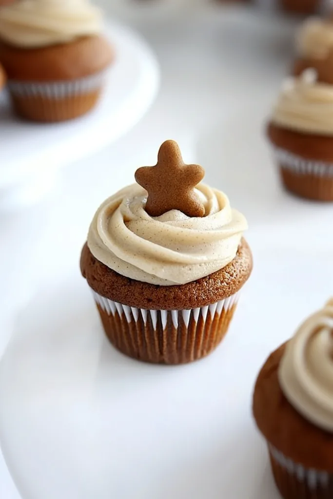 Cupcake topped with swirled frosting and a starโshaped cookie decoration.