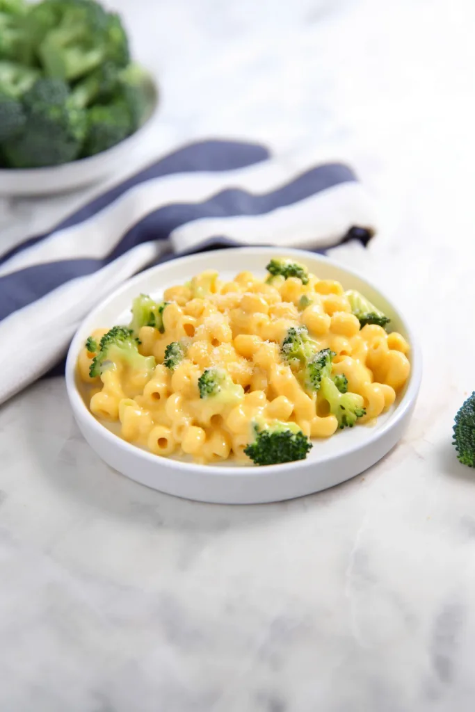 Bowl of cheesy elbow pasta topped with vibrant green broccoli pieces