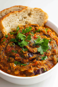 Thick, savory vegetable dip with a glossy finish, paired with golden bread on the side.