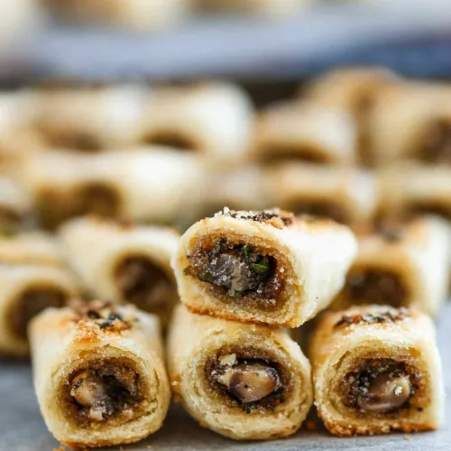 Homemade baked appetizer rolls with flaky pastry shells and flavorful mushroom stuffing