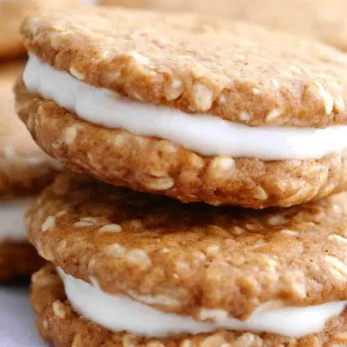 Close-up of two chewy oatmeal cookies pressed together with smooth white cream inside