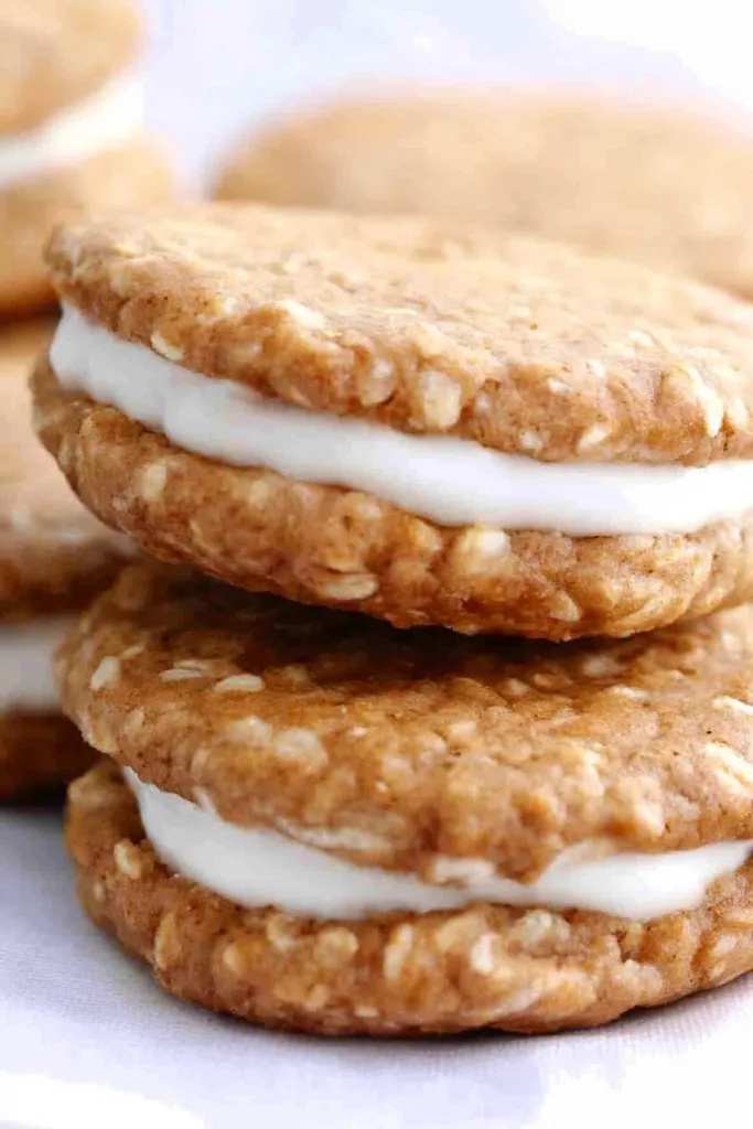 Close-up of two chewy oatmeal cookies pressed together with smooth white cream inside