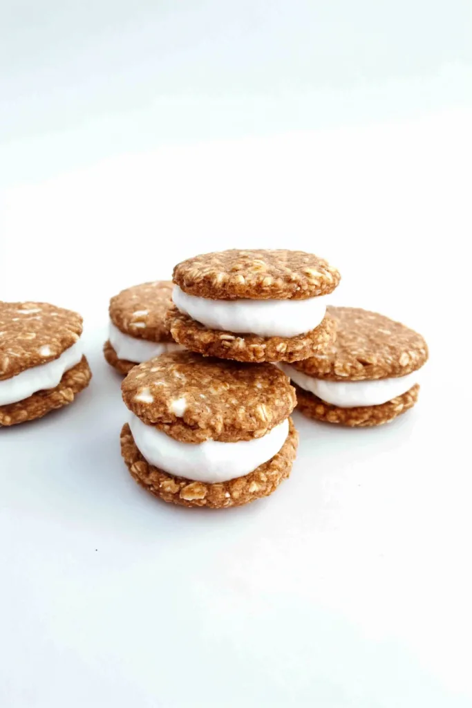 Neatly arranged cookies with crisp edges and a thick layer of cream peeking out