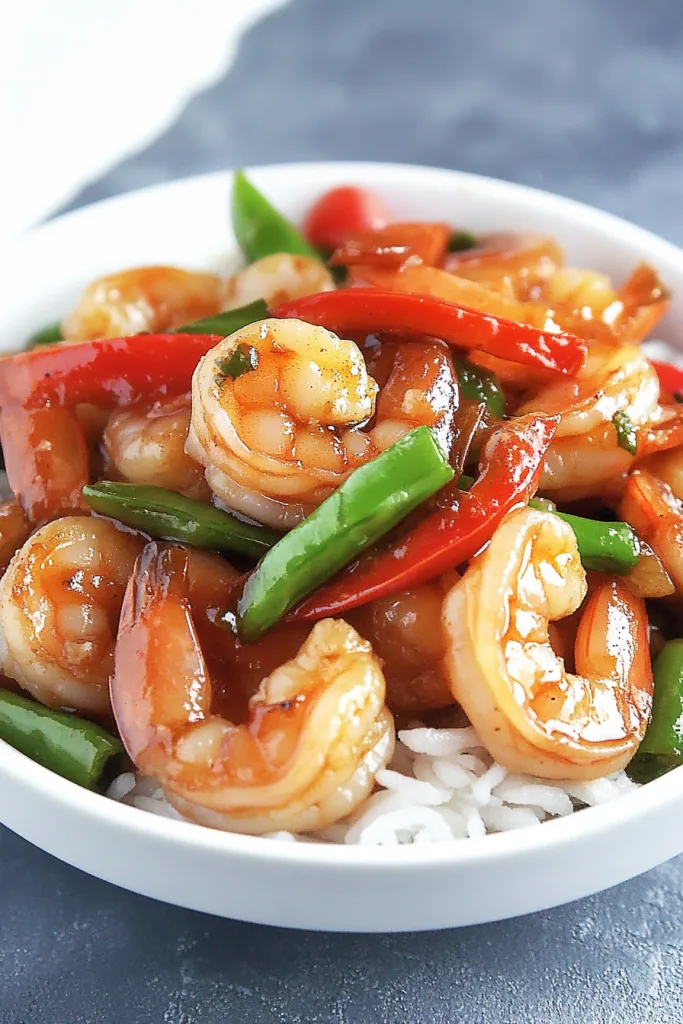 Panda Express sizzling shrimp plated over rice, showcasing bold colors and glossy sauce.