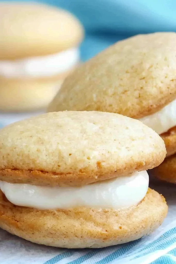 Close-up of round cake-like cookies showing smooth tops and glossy cream centers.