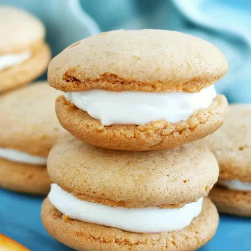 Dessert sandwiches arranged neatly, contrasting warm tones with a cool background.