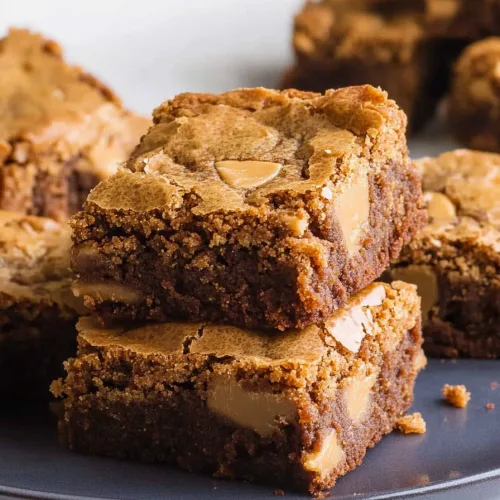 Close-up of dense brownies showing a rich, moist texture and glossy surface.