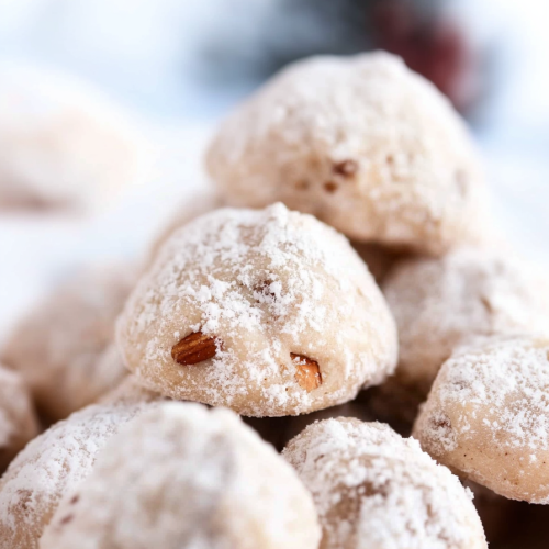 Stack of sugarโcovered cookies showing soft, nutโfilled center