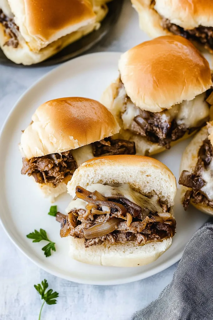 Golden slider buns filled with juicy beef and melted cheese, arranged neatly on a serving plate.