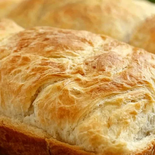 Golden-brown loaves with soft texture displayed on kitchen towel