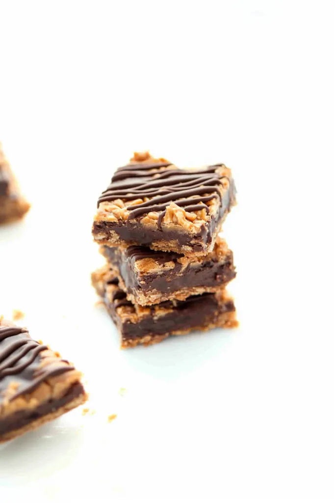 Stacked cookie bars with a chewy texture and dark chocolate drizzle