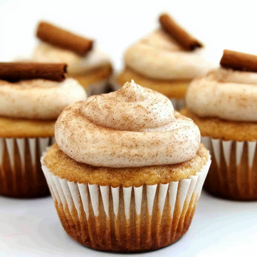 Vanilla cupcake topped with cinnamon frosting and a cinnamon stick garnish.
