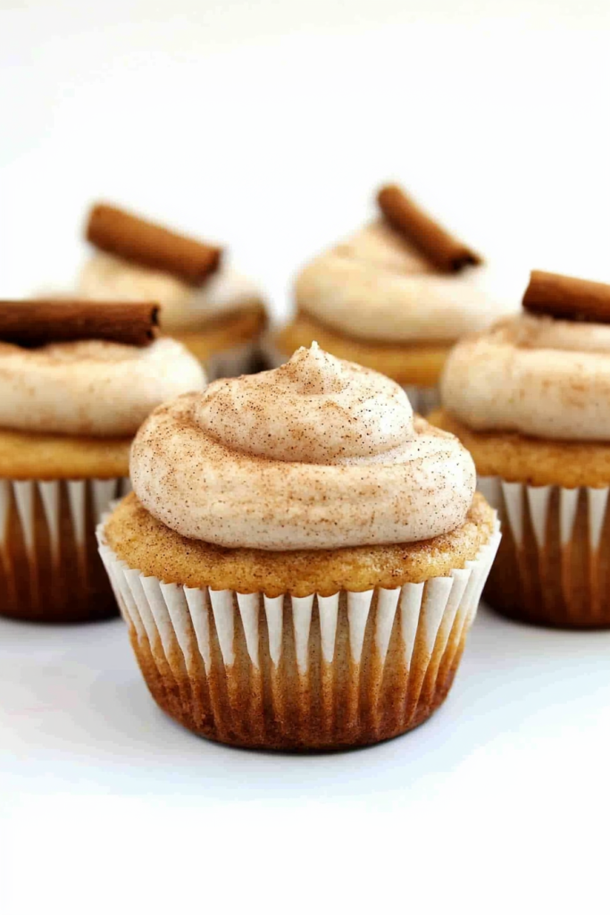 Vanilla cupcake topped with cinnamon frosting and a cinnamon stick garnish.