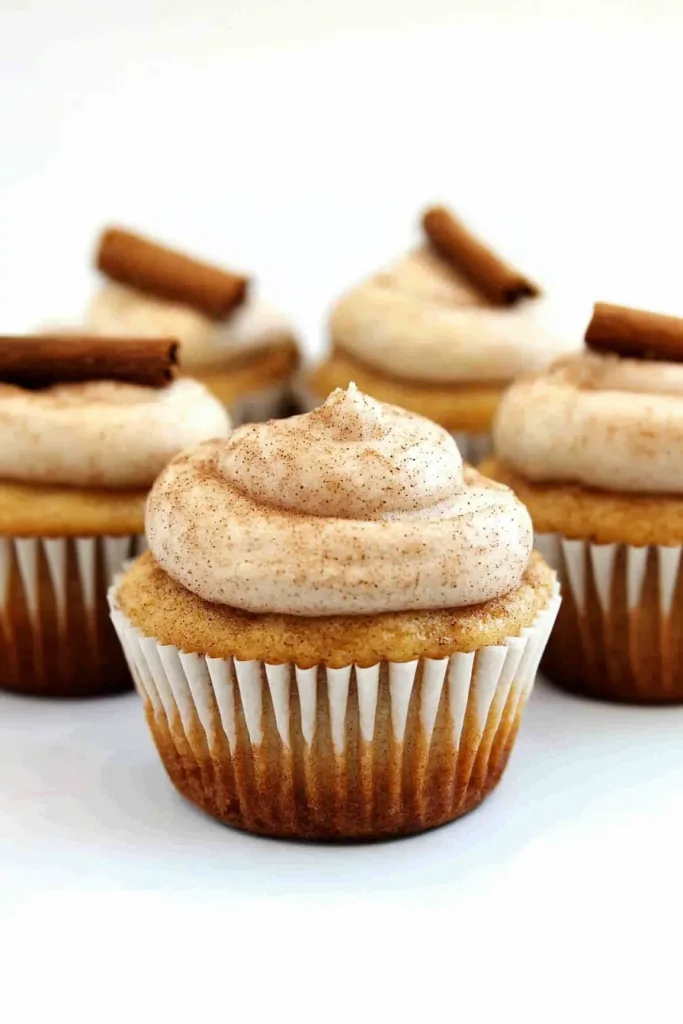 Vanilla cupcake topped with cinnamon frosting and a cinnamon stick garnish.