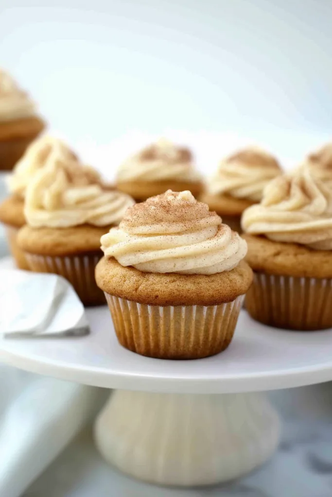 Homemade cupcakes with swirls of spiced buttercream frosting on a white background.