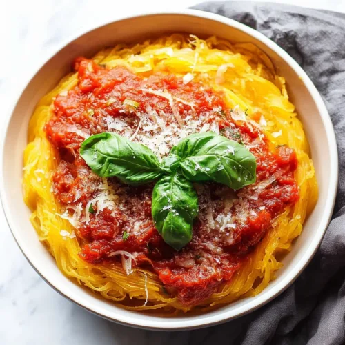 Bright yellow squash strands layered under thick red sauce with a dusting of Parmesan.