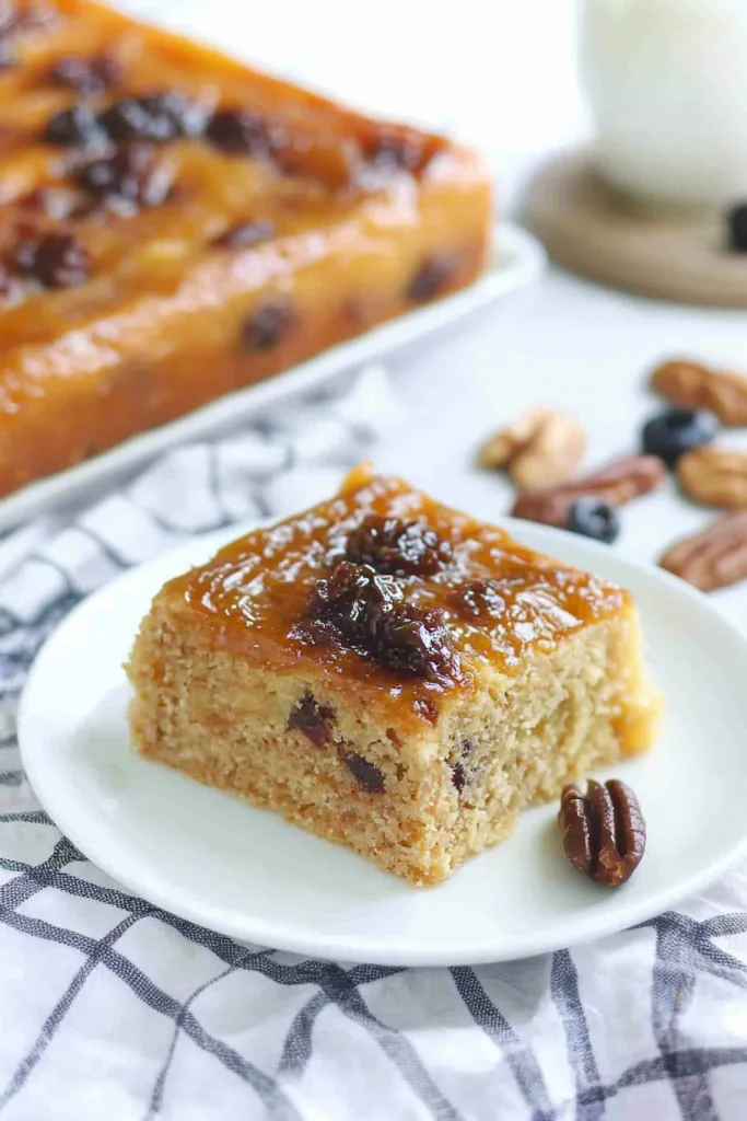 Moist layered cake with caramel glaze on a white plate.