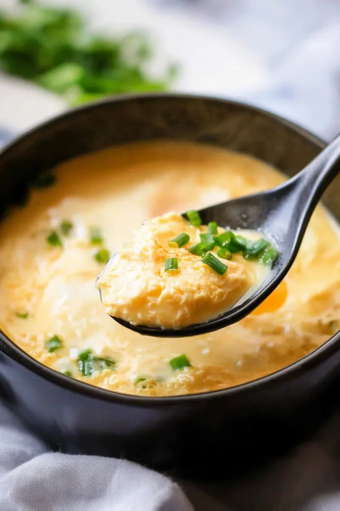 Steamed egg Korean-style presented in a rustic bowl, showcasing its soft texture and garnish.