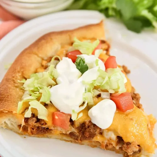 Tasty Taco Bake with Crescent Rolls served on a white plate with fresh toppings.
