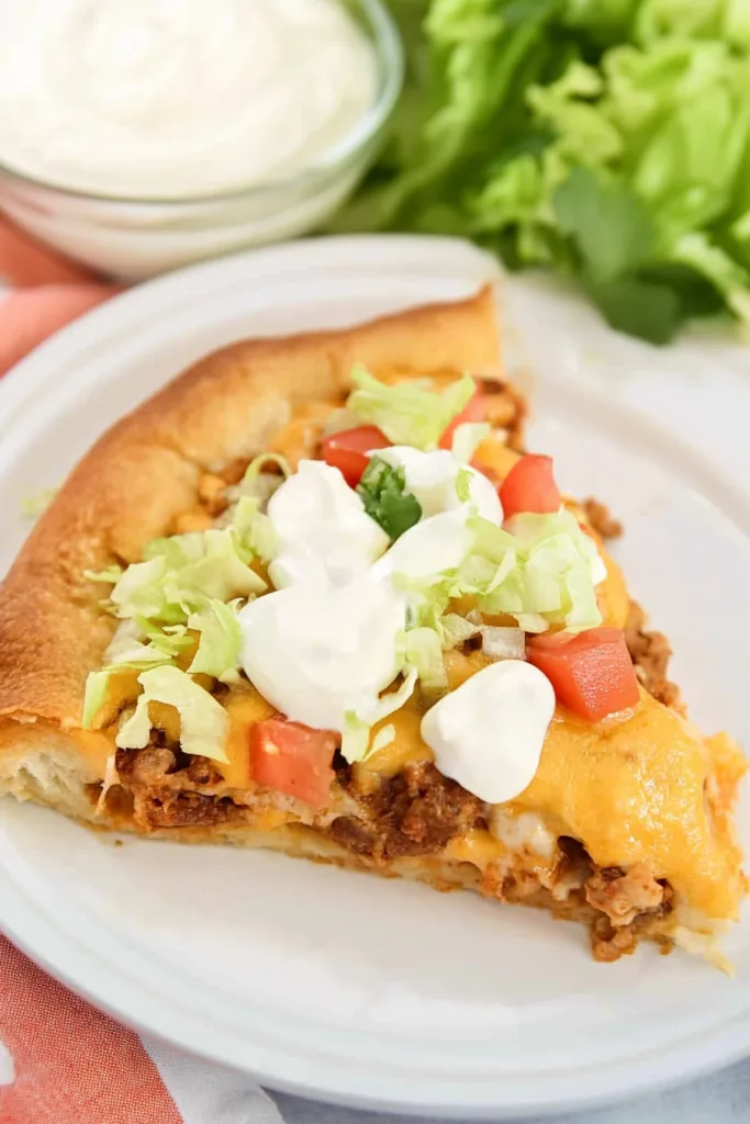 Tasty Taco Bake with Crescent Rolls served on a white plate with fresh toppings.