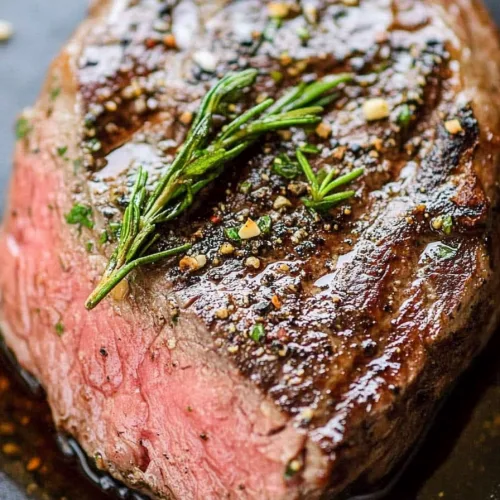 Succulent venison steak served hot, showcasing the contrast between charred edges and tender interior.