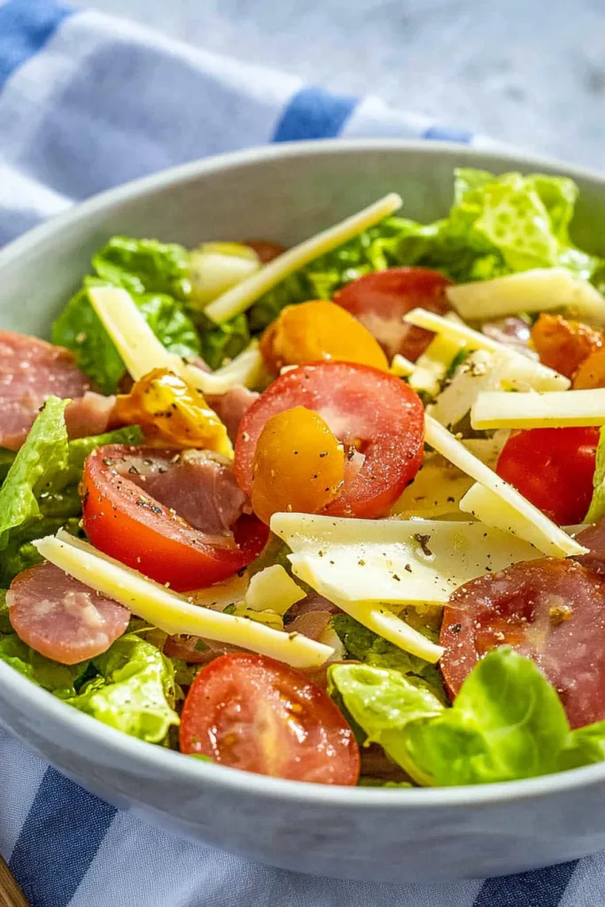 Bright mix of lettuce, tomatoes, and eggs presented in a simple white dish.