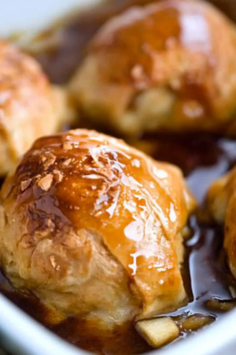 Rich, caramel-coated apple dumpling highlighting the contrast of crisp pastry and soft fruit.