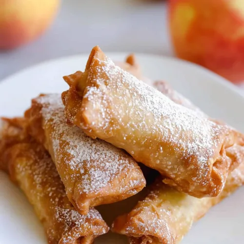 Warm pastry rolls with a golden crust, paired with apples for a rustic touch.