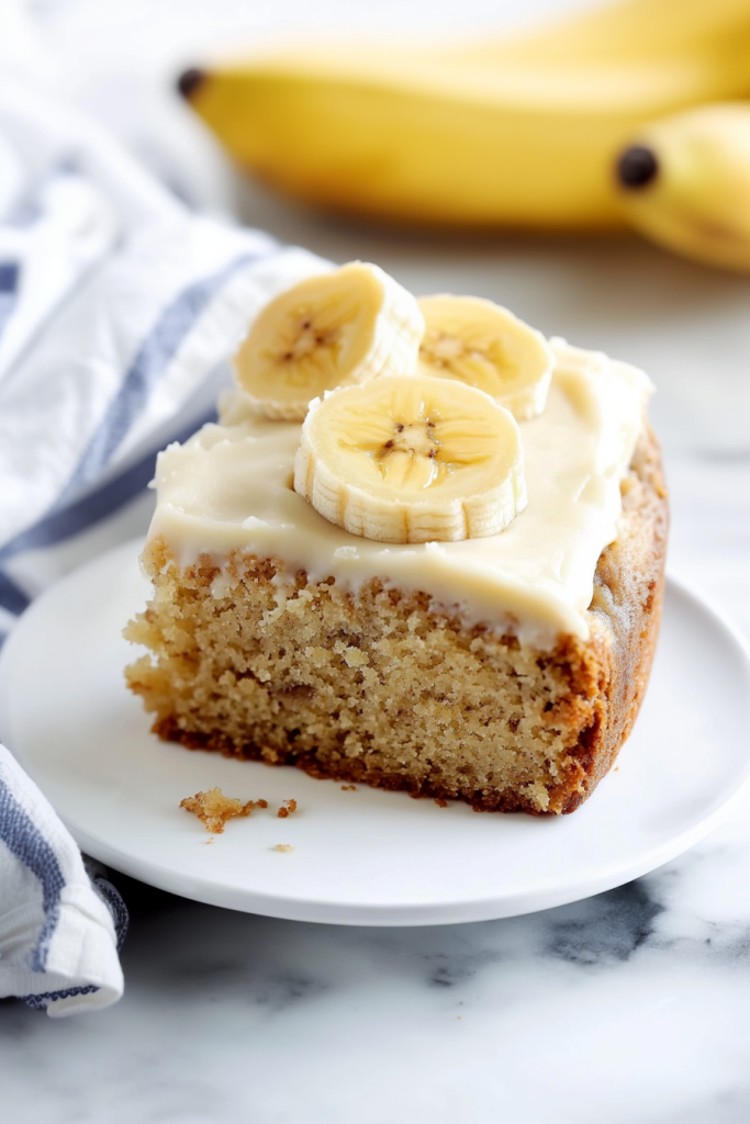 Banana Cake Recipe served with sliced bananas on top.