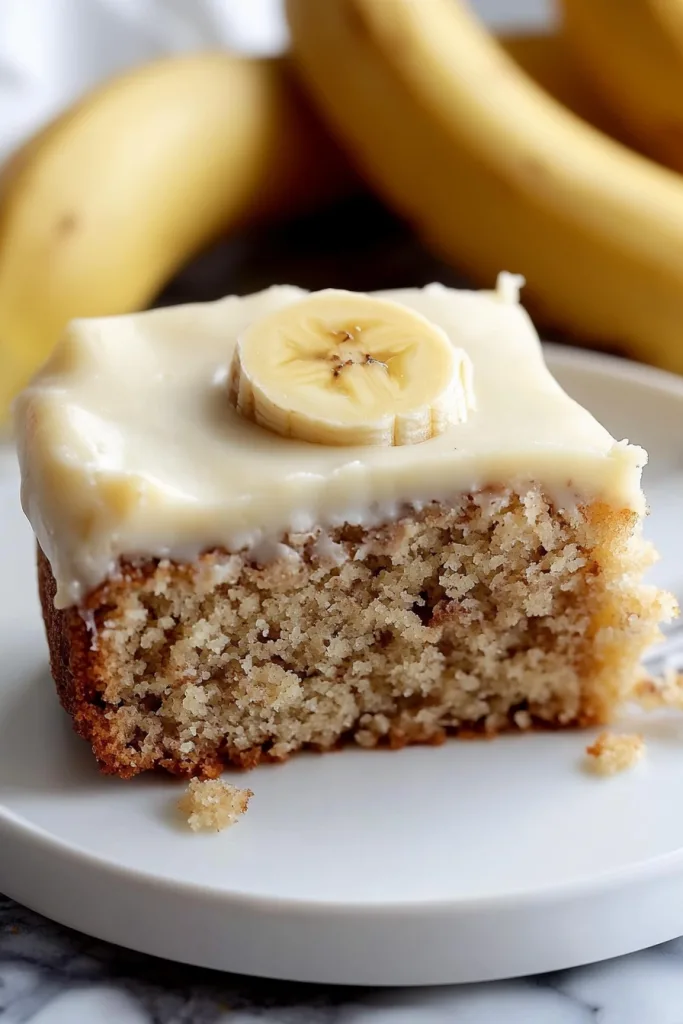 Slice of moist golden cake topped with creamy frosting.