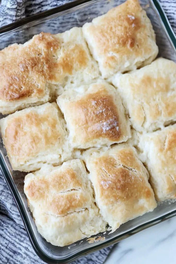 Freshly baked biscuits arranged in a rustic style on a serving dish.