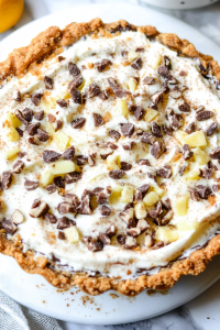 Creamy pie topped with chocolate chunks and diced fruit.