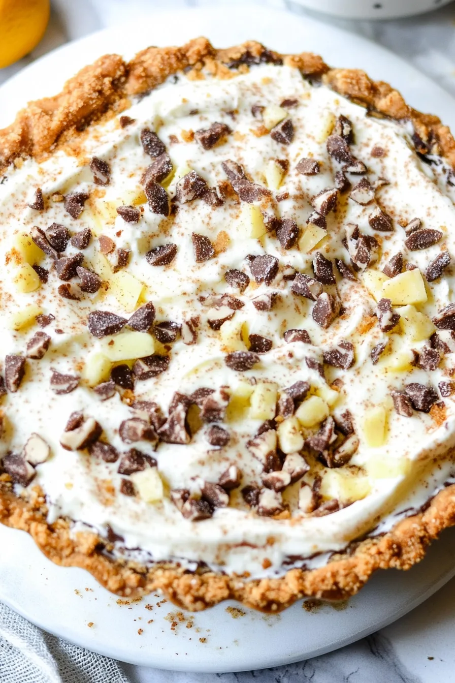 Creamy pie topped with chocolate chunks and diced fruit.