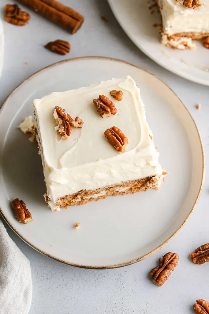 Overhead view of frosted cake slice on a white plate.