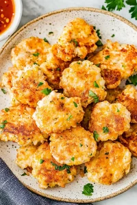Freshly cooked fritters arranged neatly, emphasizing golden sear and cheesy filling.