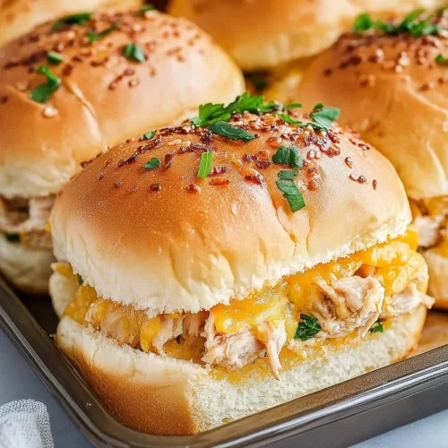 Small sandwiches arranged neatly, highlighting fluffy bread and savory filling.