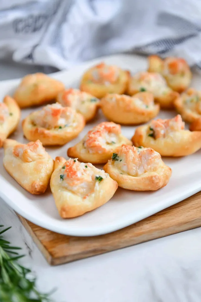 Neatly arranged seafood pastries on a white plate, ready to serve.