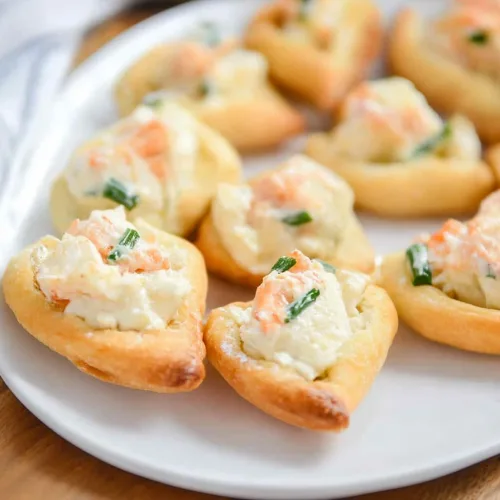 Final shot of golden-brown appetizers with creamy filling and fresh herbs.