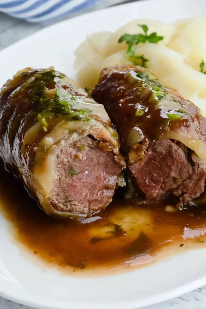 Hearty plate featuring beef roulade with smooth mashed potatoes.