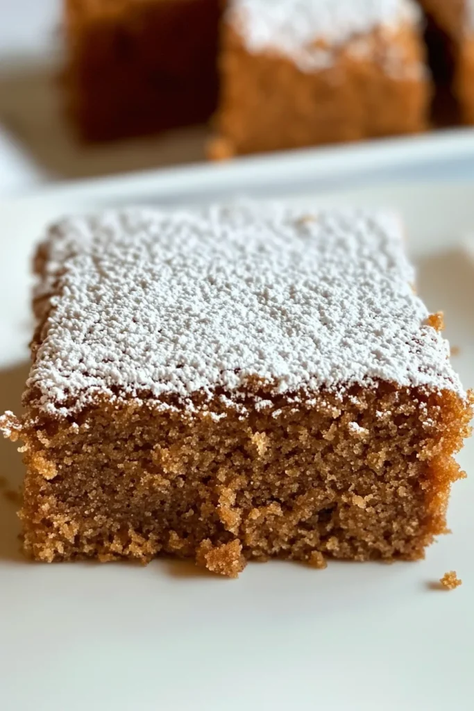Close-up of moist brown cake showing soft crumb texture and sugar coating.