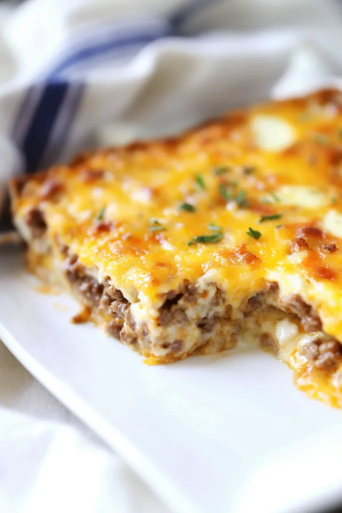 Slice of casserole highlighting sausage pieces and creamy egg mixture.