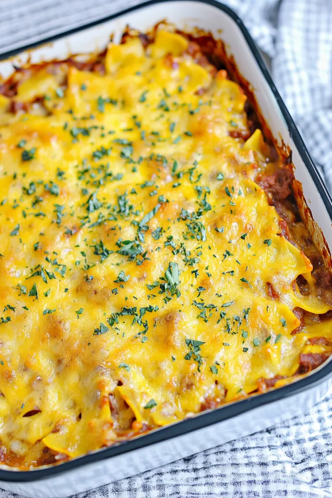 Close-up of creamy macaroni mixed with savory ground meat and bubbling cheese.