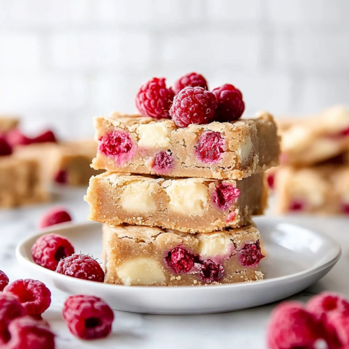 Fresh raspberries and creamy chocolate pieces scattered around chewy bars.