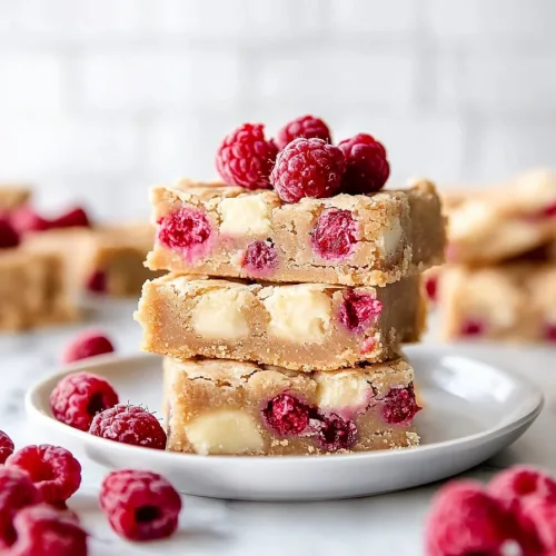 Fresh raspberries and creamy chocolate pieces scattered around chewy bars.