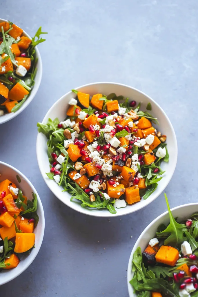 Freshly plated salad highlighting roasted vegetables, crunchy nuts, and bright toppings.