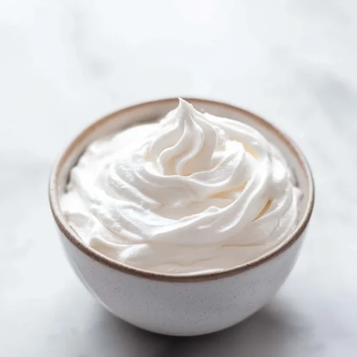 Smooth, cloud-like frosting in a white ceramic bowl.