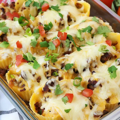 Final shot of baked shells with colorful toppings, showcasing a hearty homemade meal.