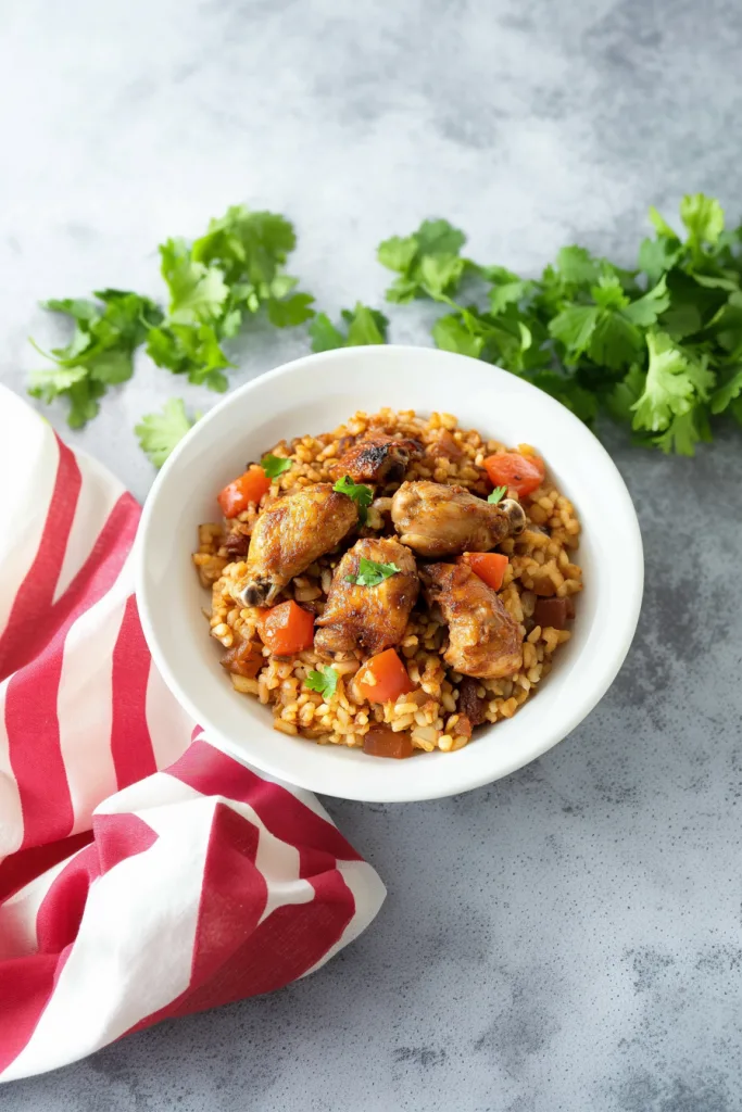 Golden brown chicken pieces nestled in seasoned rice with colorful vegetables.