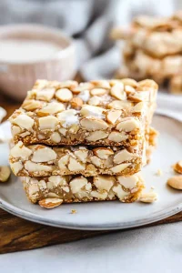 Stacked almond toffee bars with glossy caramel topping.